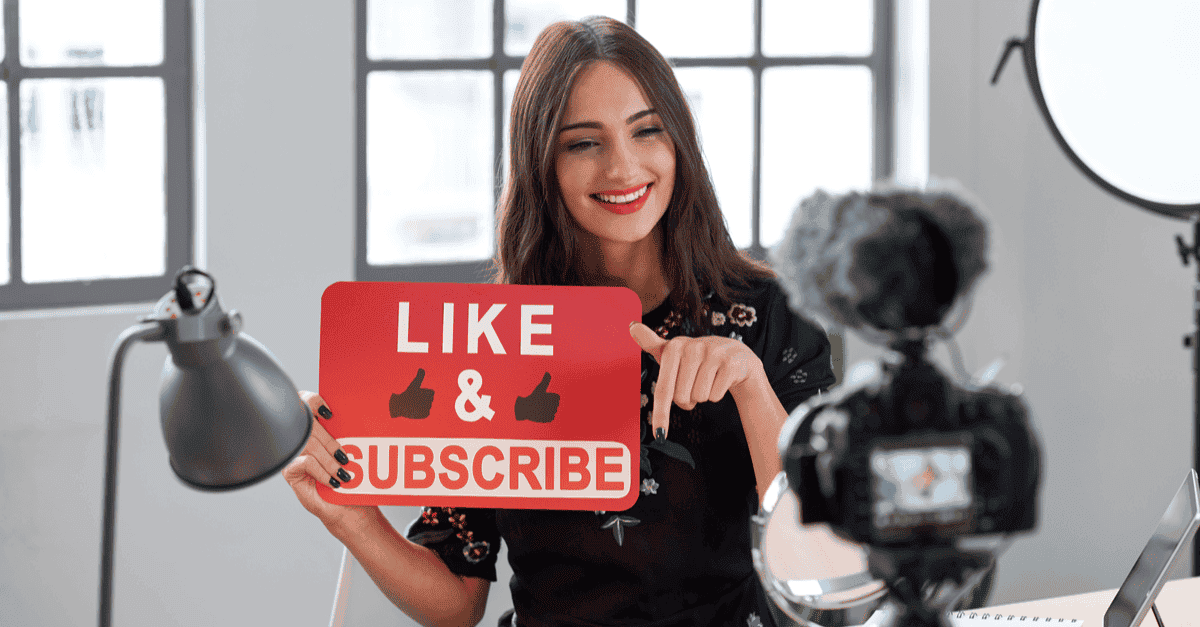 An influencer holding a sign saying Like and Subscribe.