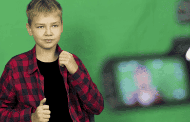 Un niño transmite en vivo o vlogs frente a una cámara, mostrando la moda.