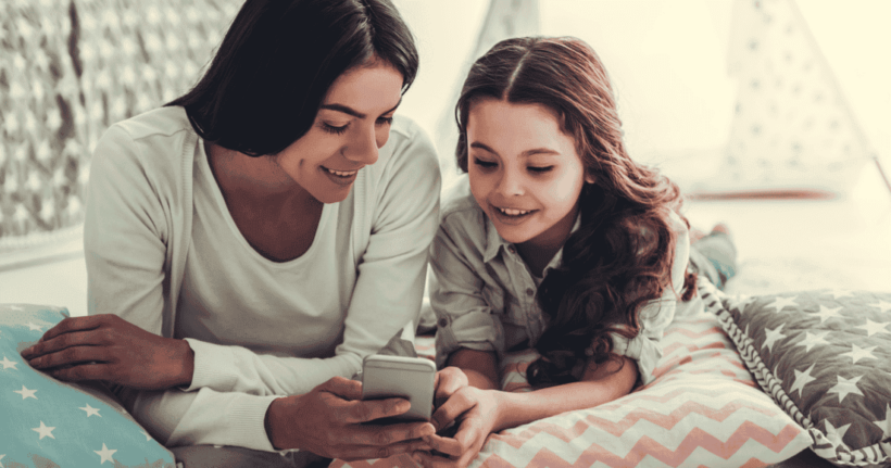 Una mamma usa uno smartphone con sua figlia.