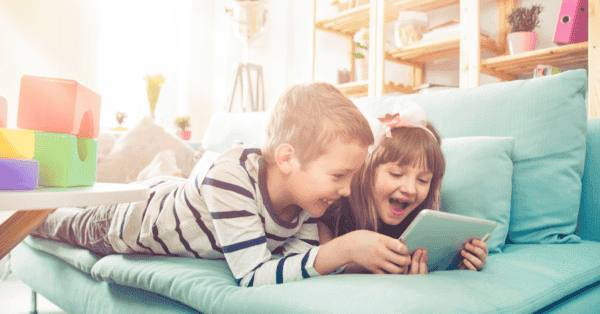 Junge und Mädchen auf dem Sofa auf dem iPad