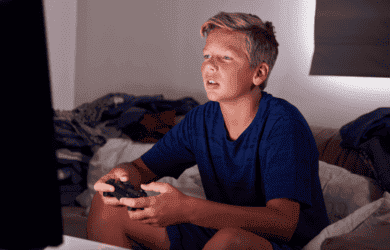 Boy setting on couch playing a game- small