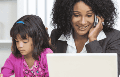 matka przez telefon, patrząc na laptopa z córką siedzącą obok jej rysunku.