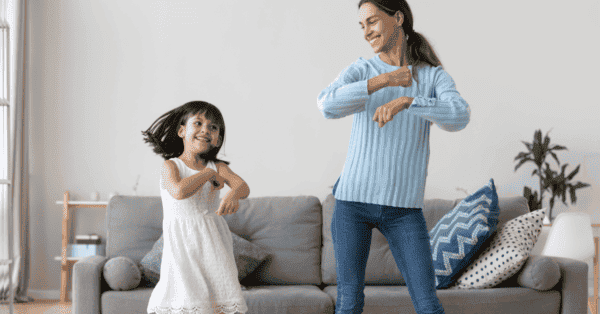Mamá e hija bailando en casa