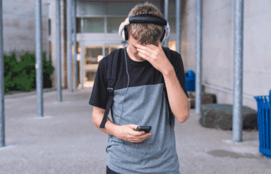 Tienerjongen die angstig mobiele telefoon gebruikt
