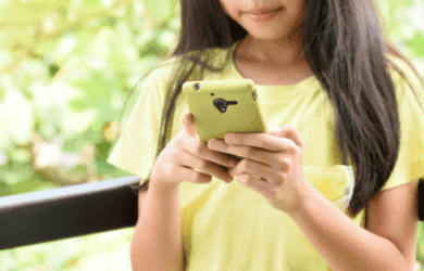 A young girls holds a smartphone.