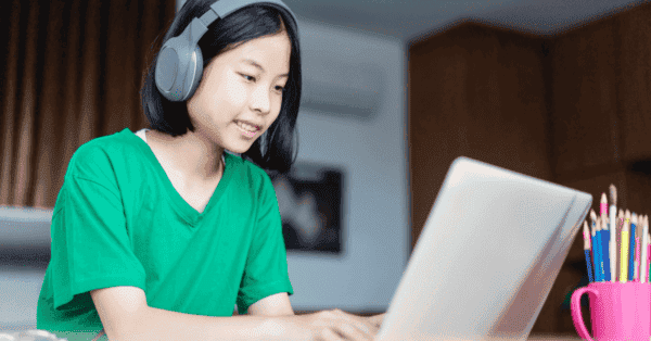 Moça com fone de ouvido e laptop
