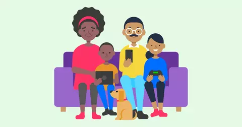 A family sits on a sofa with their devices.