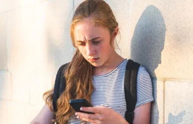 A girl frowns at her phone.