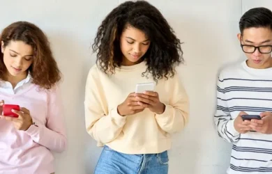 Trójka nastolatków korzysta ze swoich urządzeń.