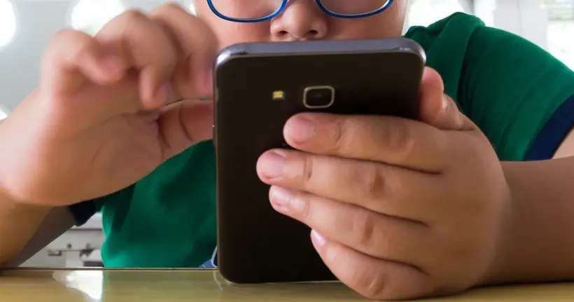 A child holds their smartphone.