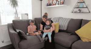 A mom with her two small children in the sofa