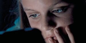 A close up of Evie from the screen time ad using her device.