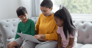 Mum and two children looking at a laptop on the sofa