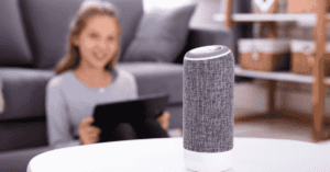 girl on device controlling a smart speaker