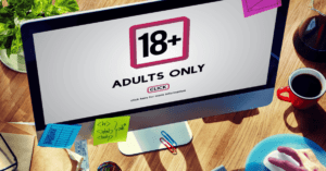 Een computermonitor op een desktop. Tekst op de monitor luidt: "18+ Adults Only. Klik hier voor meer informatie"