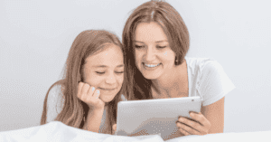 Moeder en kind die met tablet in haar hand glimlachen