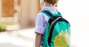 A young boy wears a backpack.