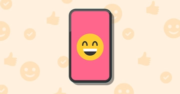 Un smartphone avec l'émoji rieur sur l'écran