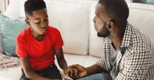 Father and sad looking son having a conversation