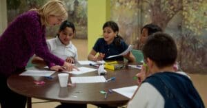 A teacher helps a group of students.