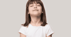 Young girl taking deep breath with eyes closed.