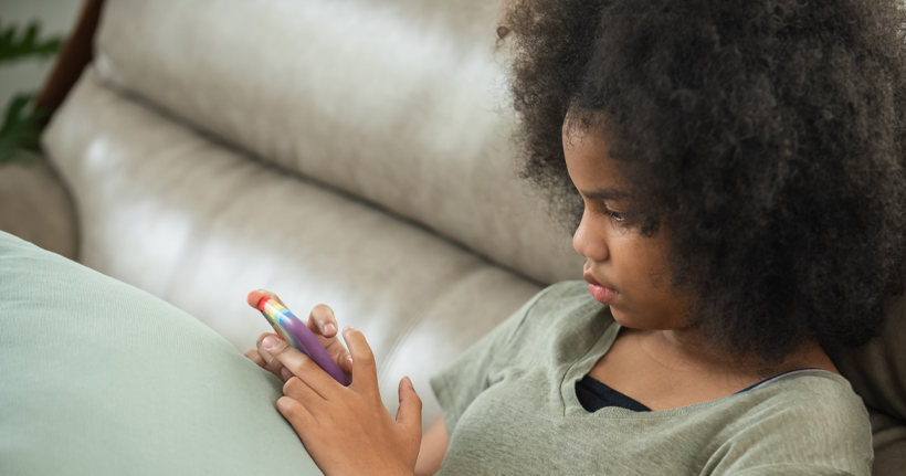 A young girl uses her smartphone.