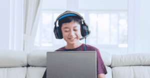 Un niño que usa unos auriculares y utiliza una computadora portátil