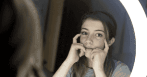 A teen girl looking at herself in the mirror