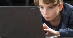 A boy uses a laptop.