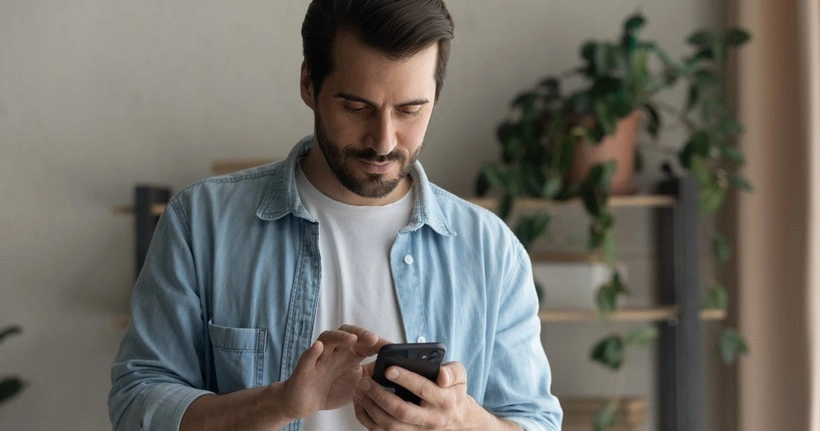 A dad uses his smartphone to report an online issue on his smartphone.