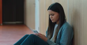 Sad teen girl on her phone
