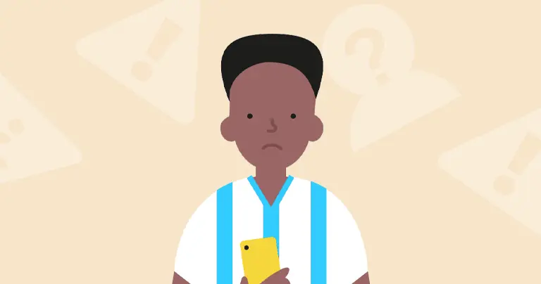 A young boy holds a smartphone and frowns.