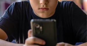 Boy with serious expression looking at phone