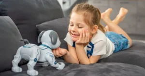 A young girl plays with a smart toy, a robot dog.