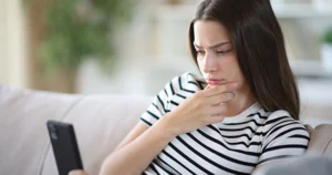 Teen looking at phone confused